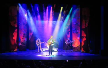 Daniel East on stage under colourful lights