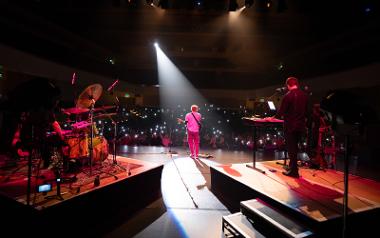 A view from behind the Shape of You band playing in front of a crowd